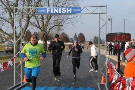 A group of people are running under a finish sign