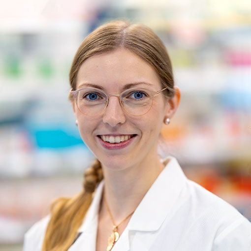 Veronika Abeln mit Brille und weißem Laborkittel lächelt in die Kamera.