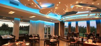 A large dining room with tables and chairs and blue lights on the ceiling. project completed by AARONS.