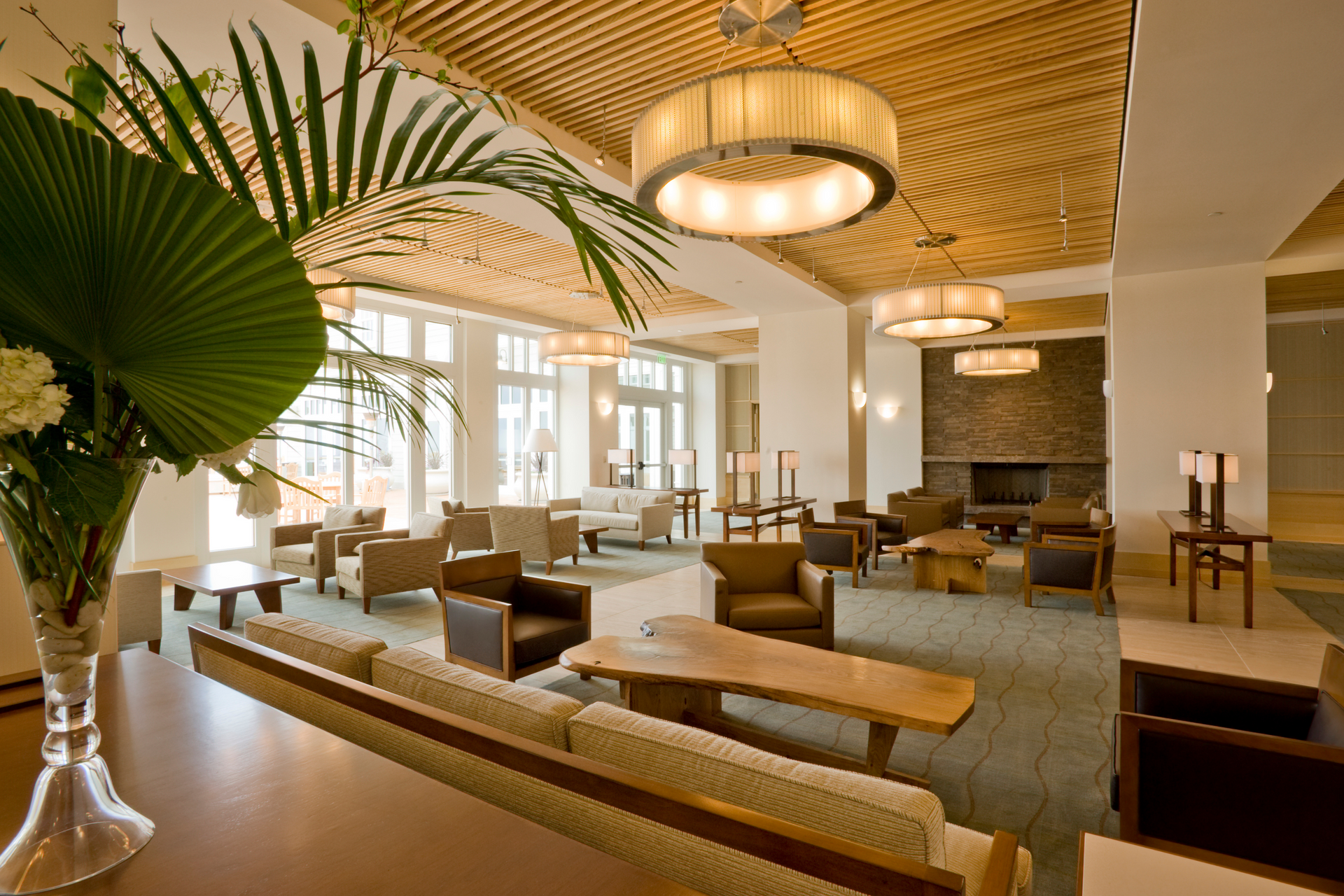 Hotel with lots of furniture and a vase of flowers beautiful custom lighting. 