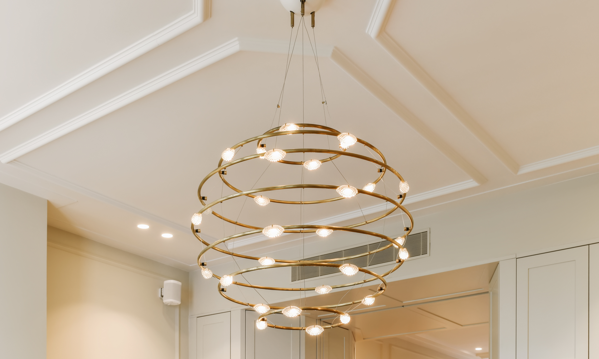 A spiral chandelier is hanging from the ceiling of a room.
