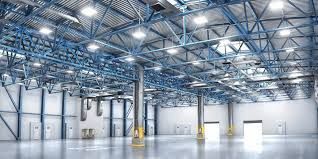 A large empty warehouse with lots of lights on the ceiling 