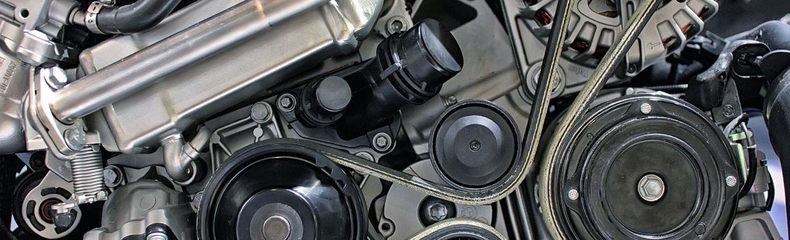 A close up of a car engine with a belt.