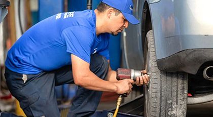 A man is cutting a tree branch with a chainsaw.
