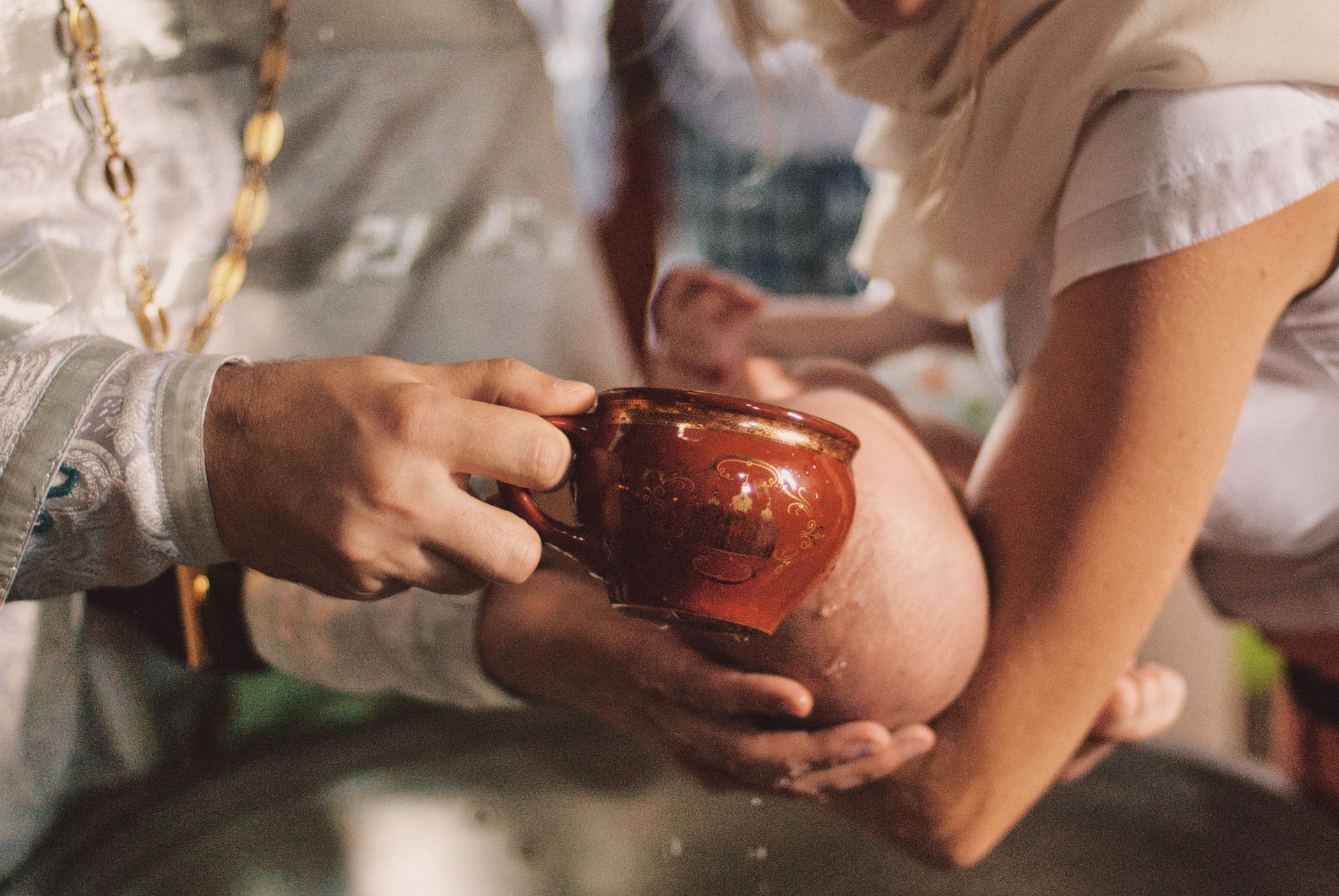 Un uomo sta versando dell'acqua nella tazza di un bambino.