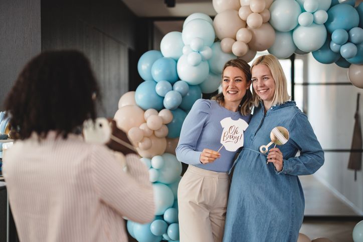 Due donne incinte posano per una foto a un baby shower.