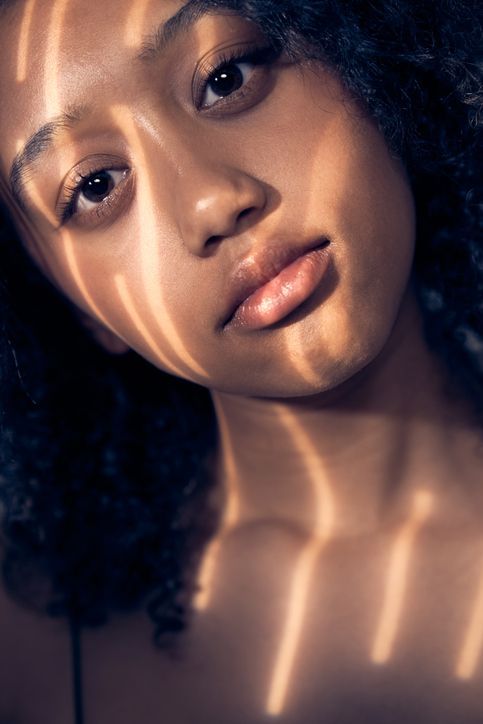 Un primo piano del volto di una donna con un'ombra sul viso.