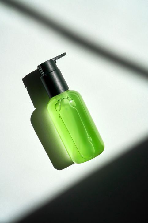 Una bottiglia verde con un tappo nero galleggia nell'aria.