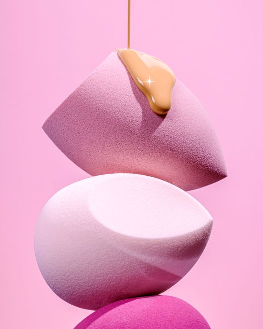 Tre spugnette per il trucco sono impilate l'una sull'altra su uno sfondo rosa.