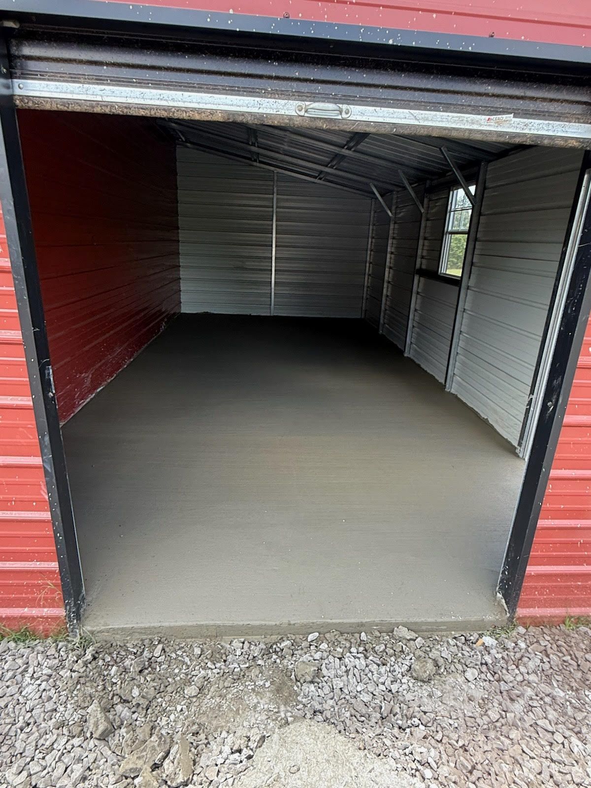 Newly poured concrete patio, divided into square sections, in an outdoor setting.