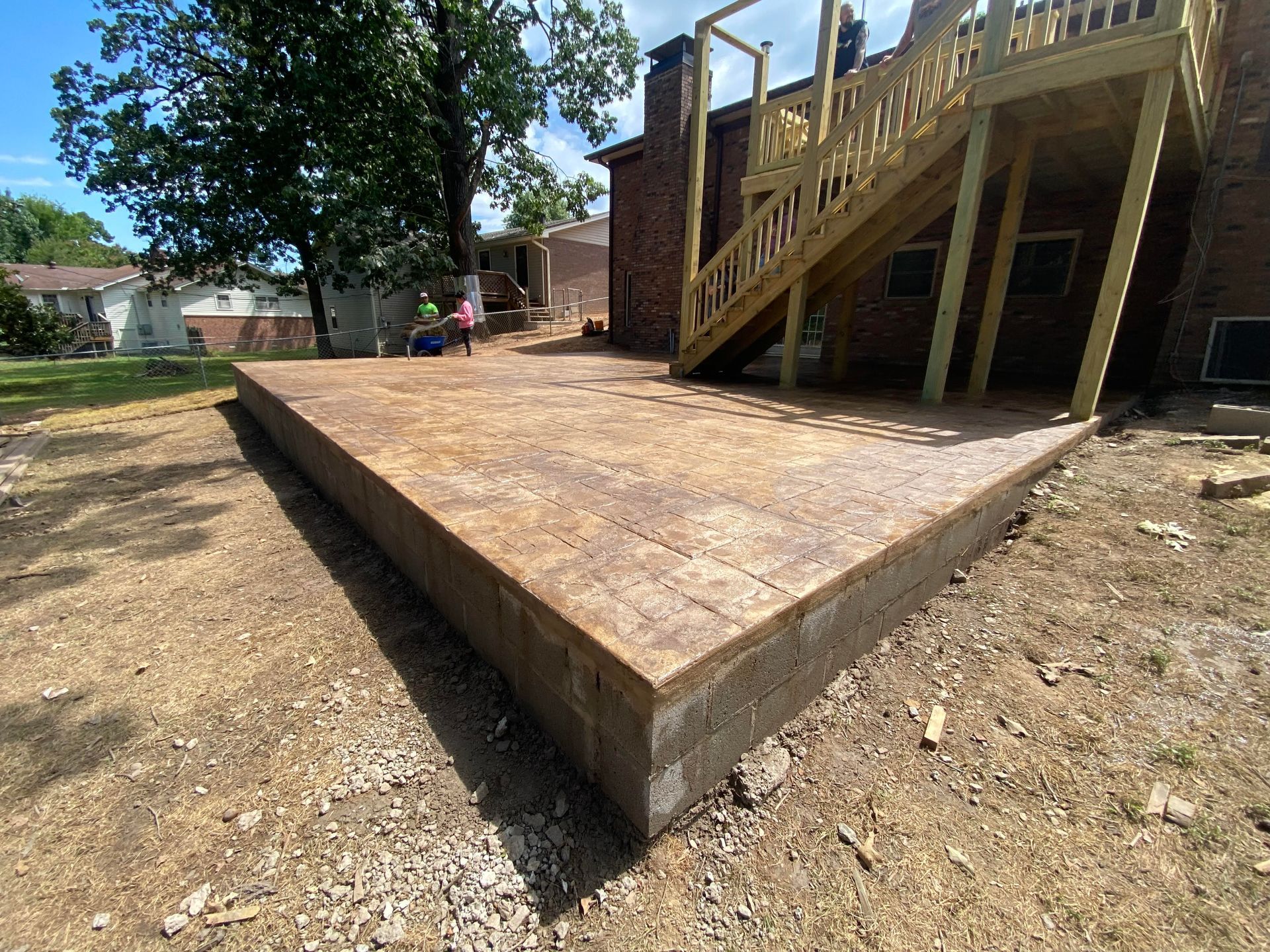 Brick pathway with alternating orange and gray geometric blocks, leading to a bench in a garden.