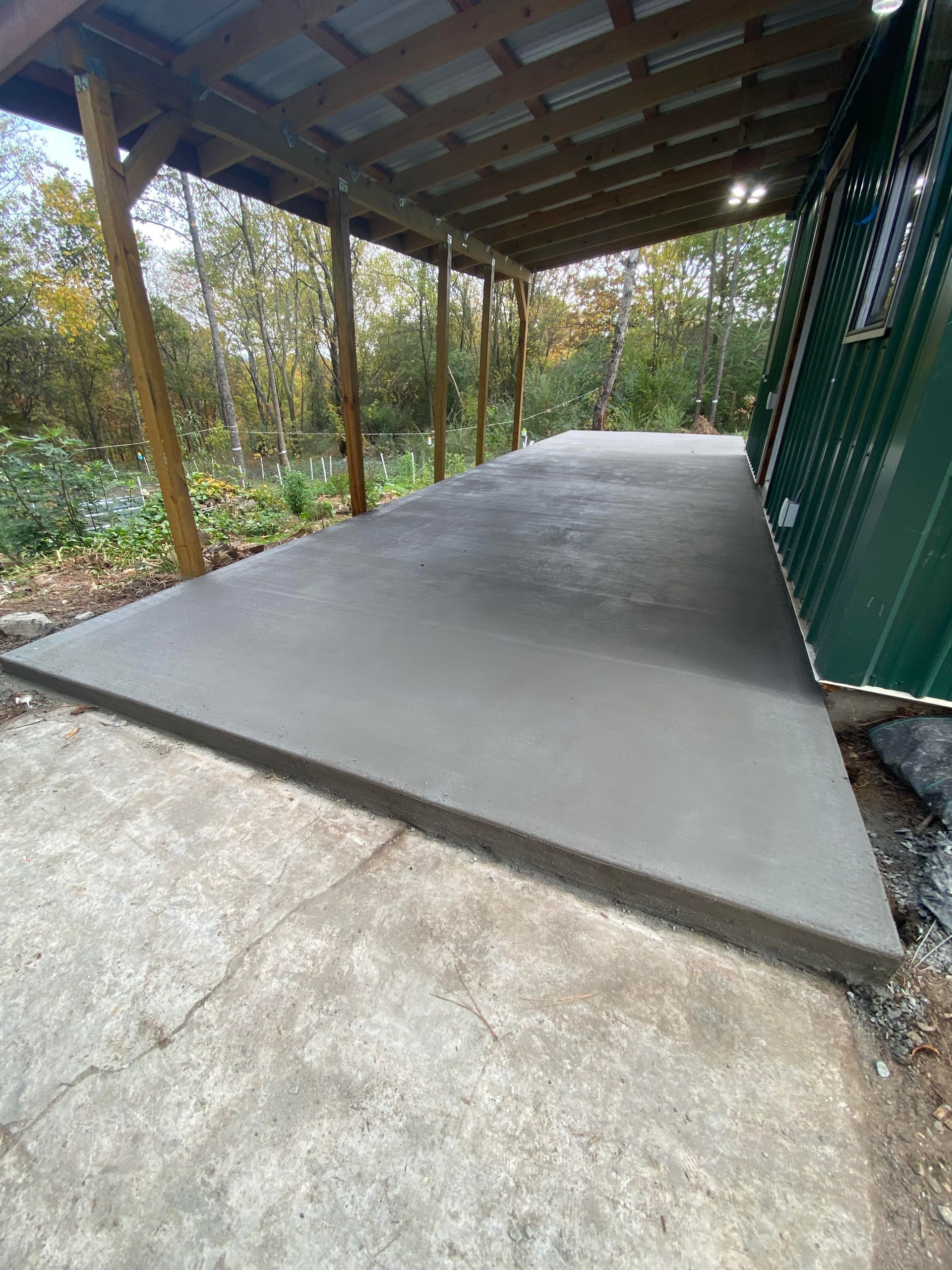 Patio with multi-colored stone tiles, lawn, and tree.