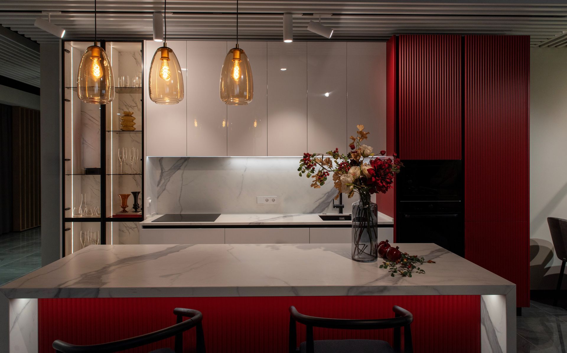 A luxury kitchen island with a marble countertop and a custom red joinery.