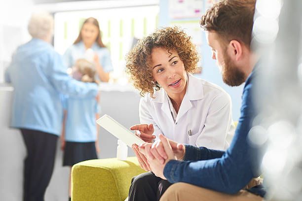A doctor is talking to a patient in a waiting room.