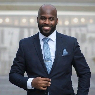 A man in a suit and tie is smiling for the camera