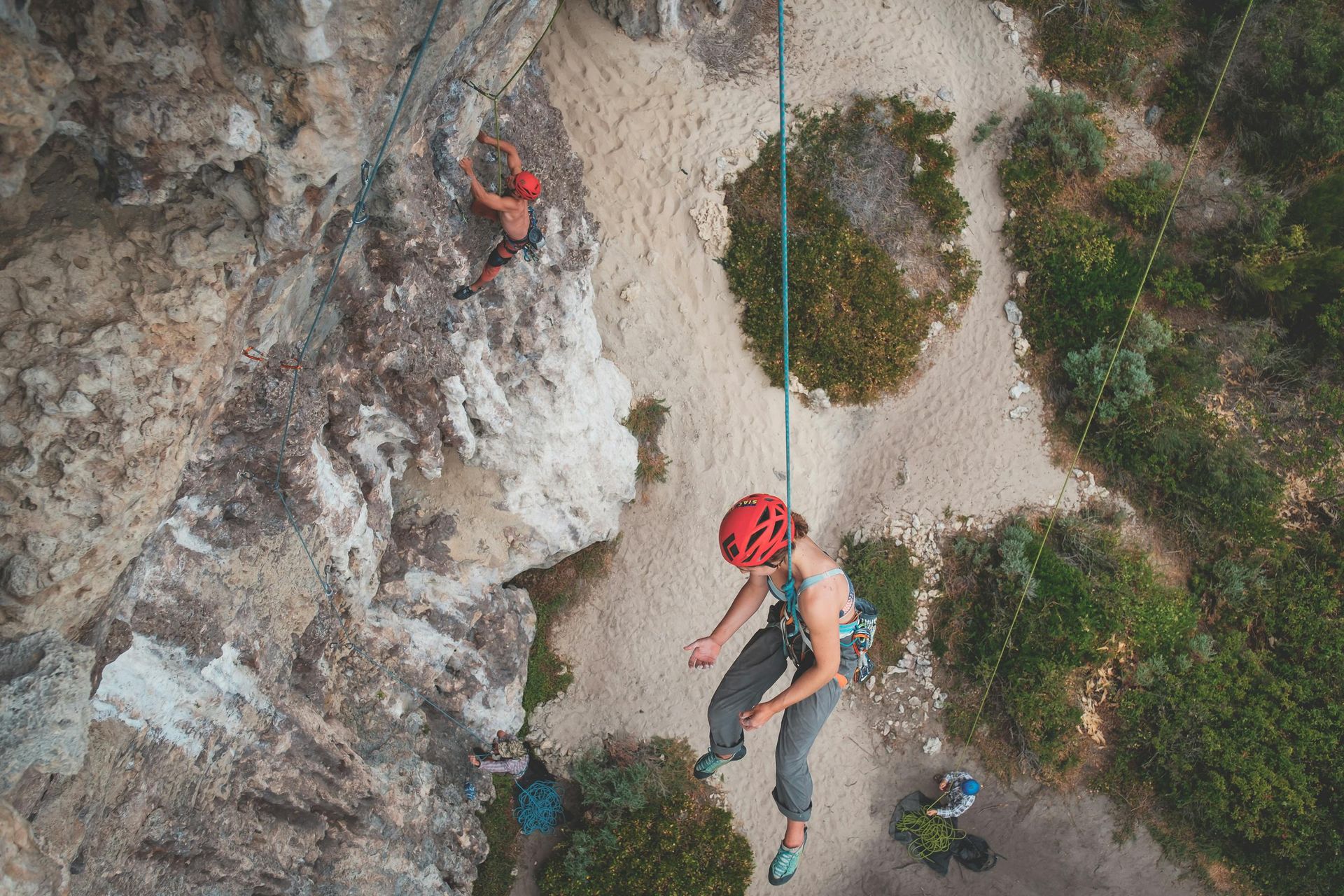An aerial view of two people climbing a rock wall.