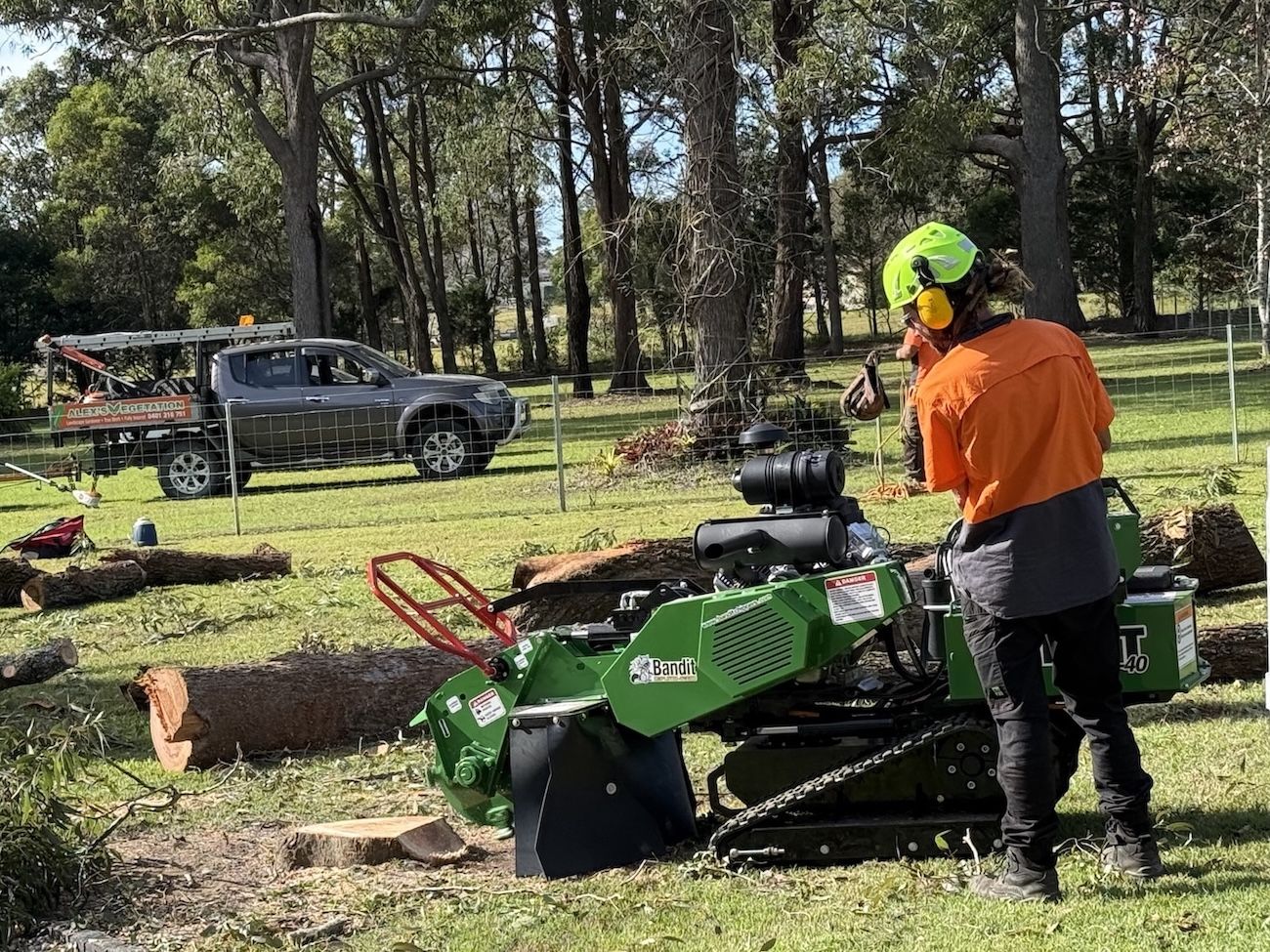 man is cutting a tree stump with machinery — Alex's Vegetation in Wauchope, NSW