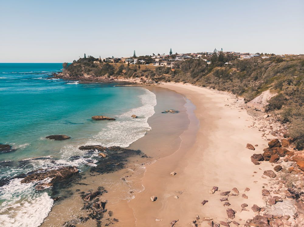 An Aerial View Of A Sandy Beach Next To The Ocean — Alex's Vegetation in Lake Cathie, NSW