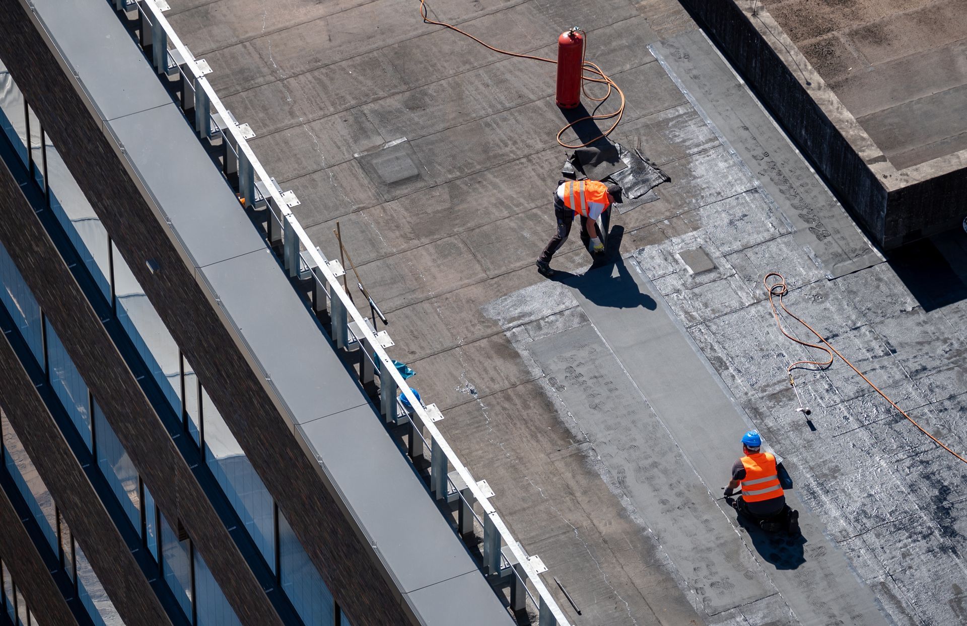 Un grupo de trabajadores de la construcción está trabajando en el techo de un edificio.