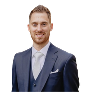 A man in a suit and tie is smiling for the camera