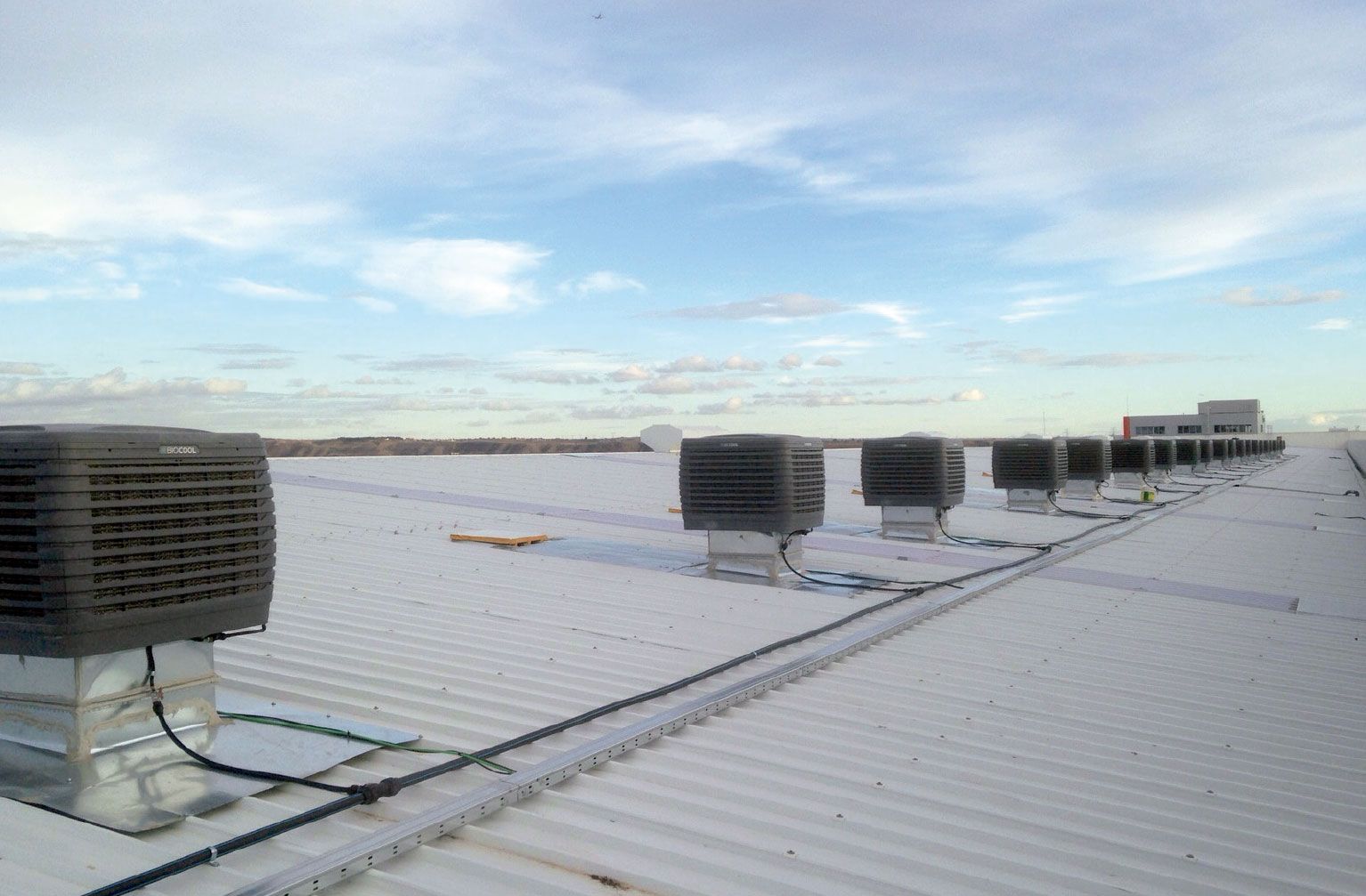 a row of air conditioners on the roof of a building .