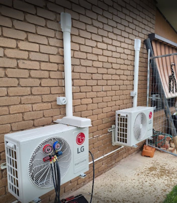 two lg air conditioners are installed on the side of a brick building .