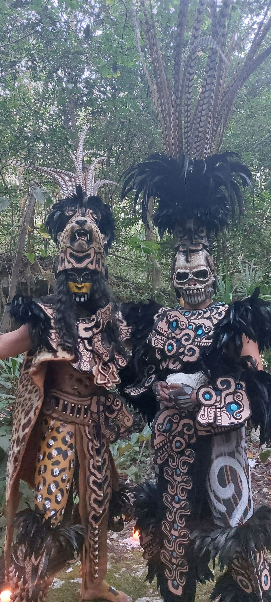 Two people in costume are standing next to each other in the woods.
