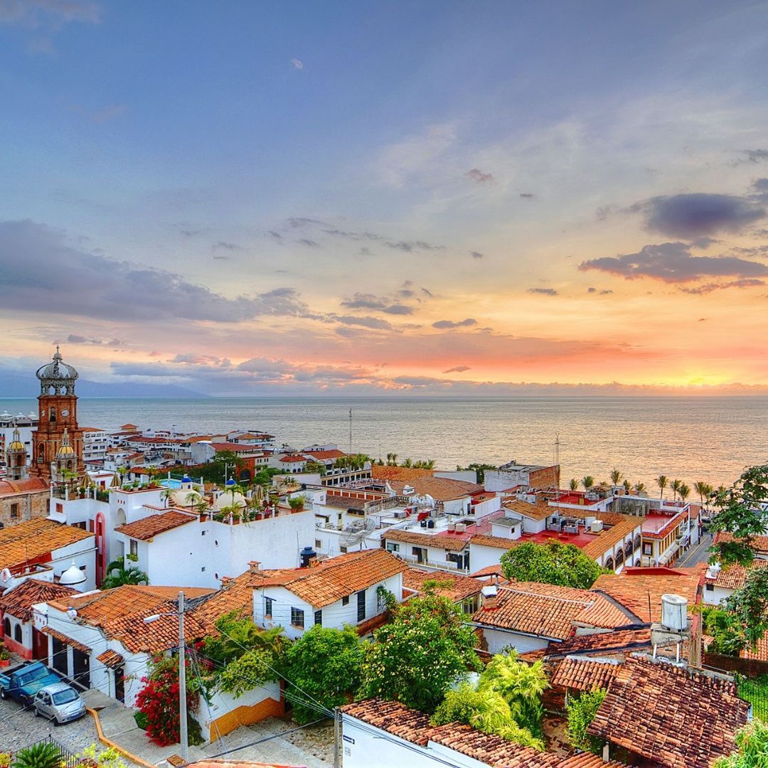 An aerial view of a small town next to the ocean at sunset.