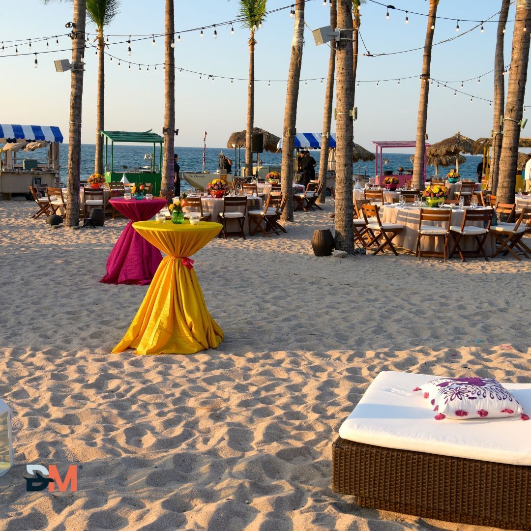 A beach with tables and chairs set up for a party