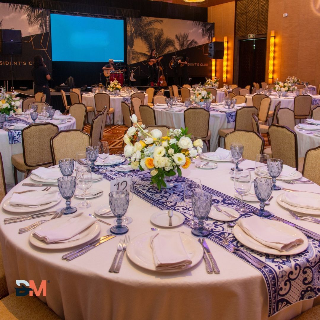 A large room with tables and chairs set up for a wedding reception.