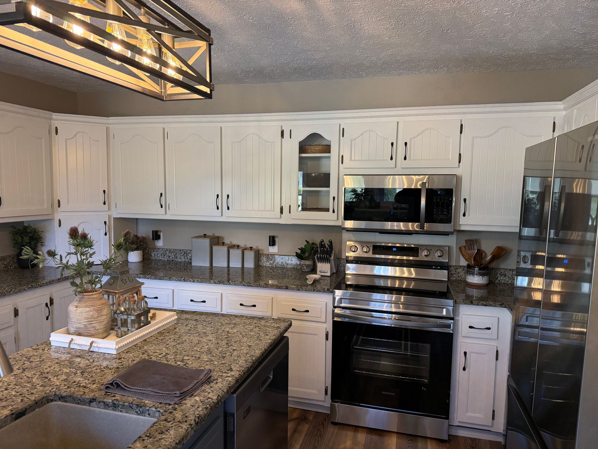 A blue island in a kitchen with white cabinets and hardwood floors.