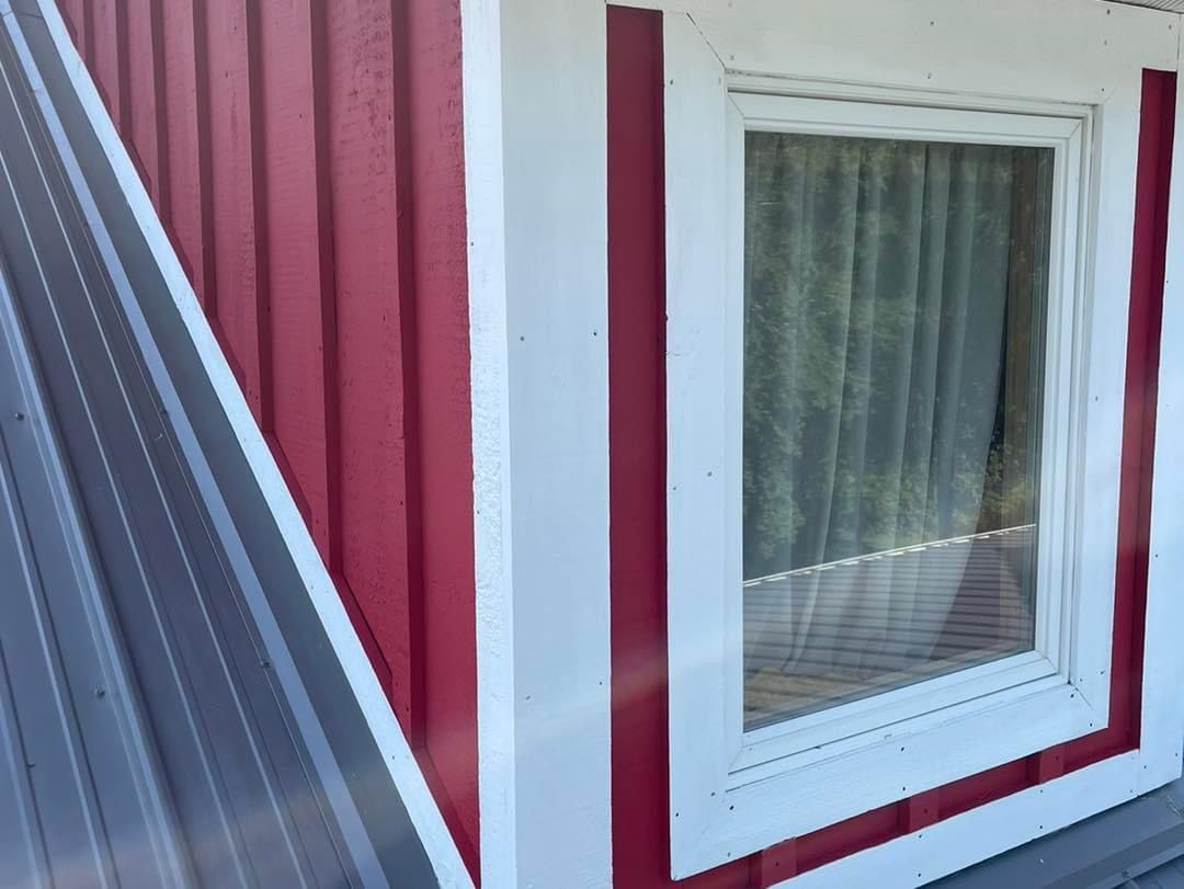 A red and white house with a window on the side.