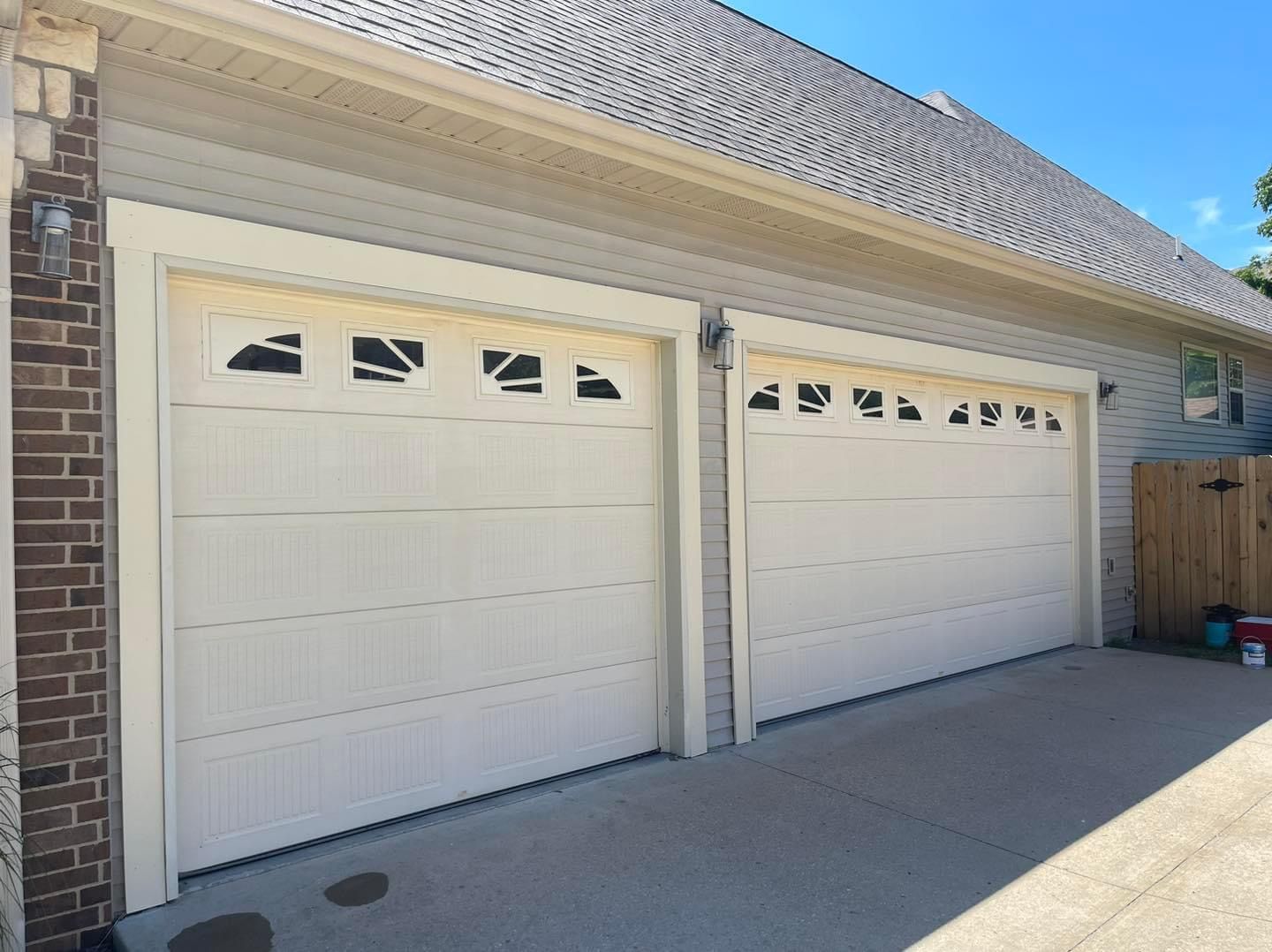 A couple of white garage doors on a brick building