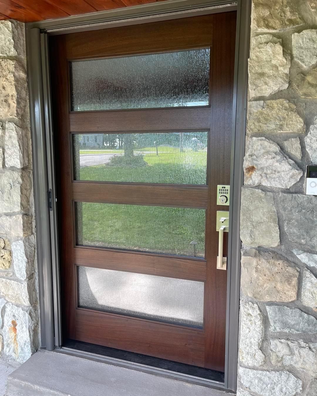 A wooden door with a stone wall behind it.