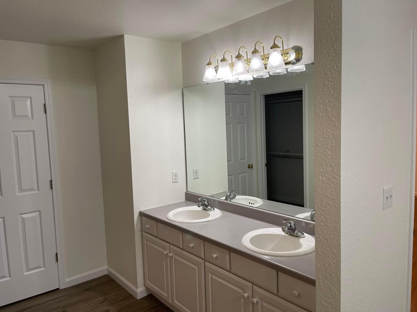 A bathroom with two sinks and a large mirror.