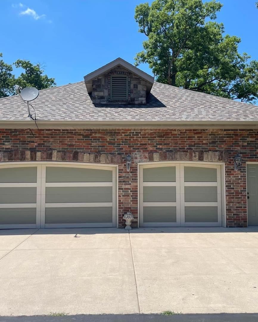 A brick house with three garage doors and a fire hydrant in front of it