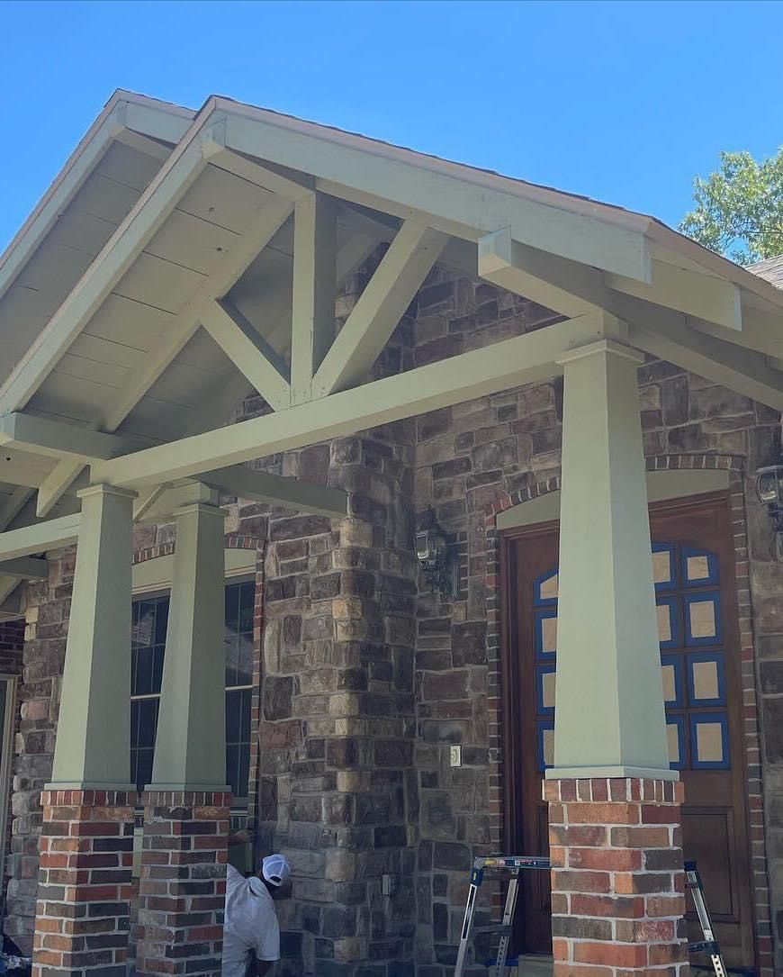 A brick house with a porch and a blue sky in the background