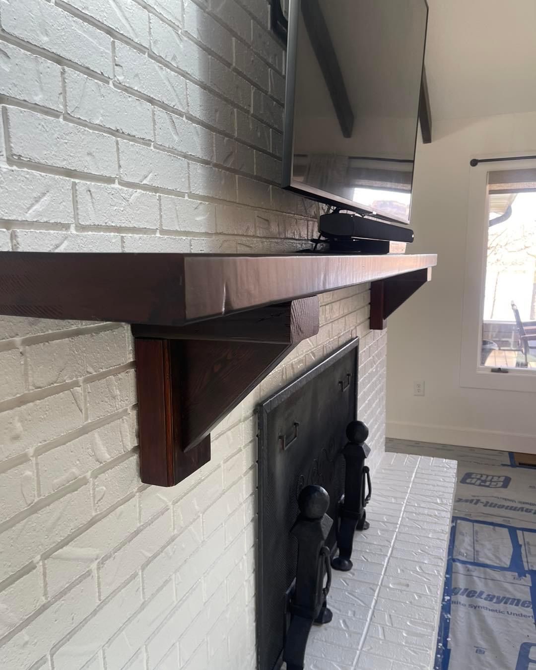 A fireplace with a wooden shelf above it