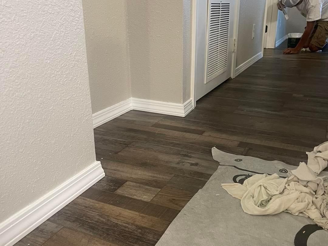 A person is standing in a hallway next to a wooden floor.