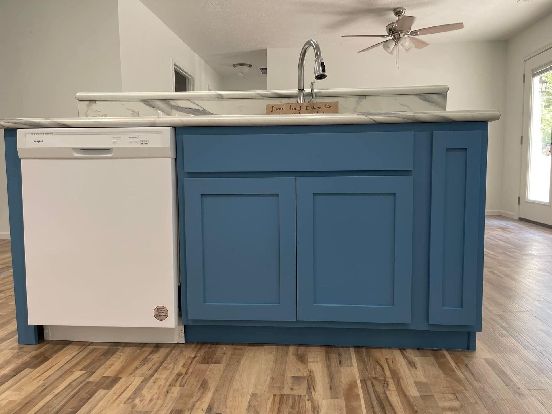 A kitchen with blue cabinets and a white dishwasher