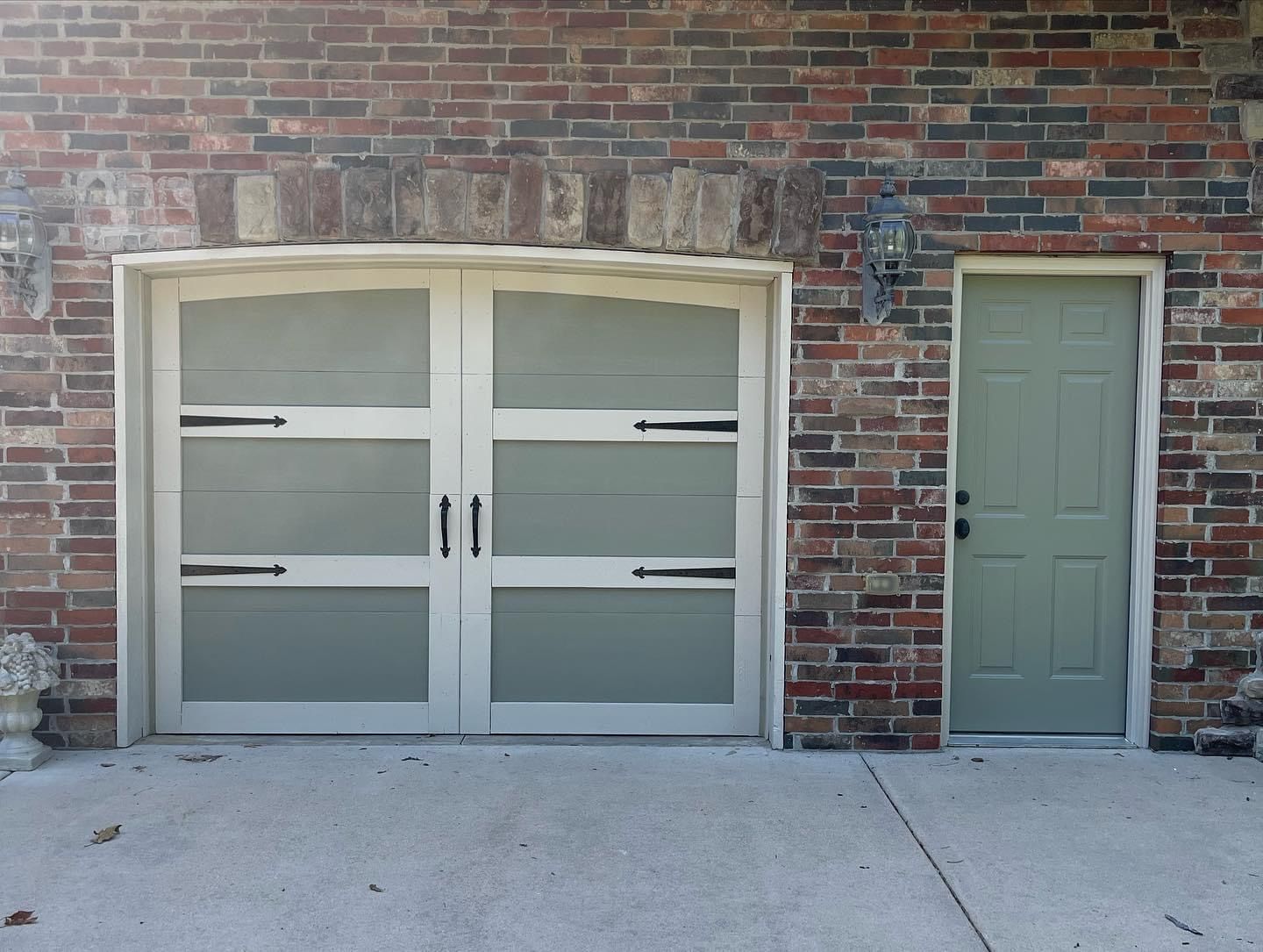 A brick building with two garage doors and a green door