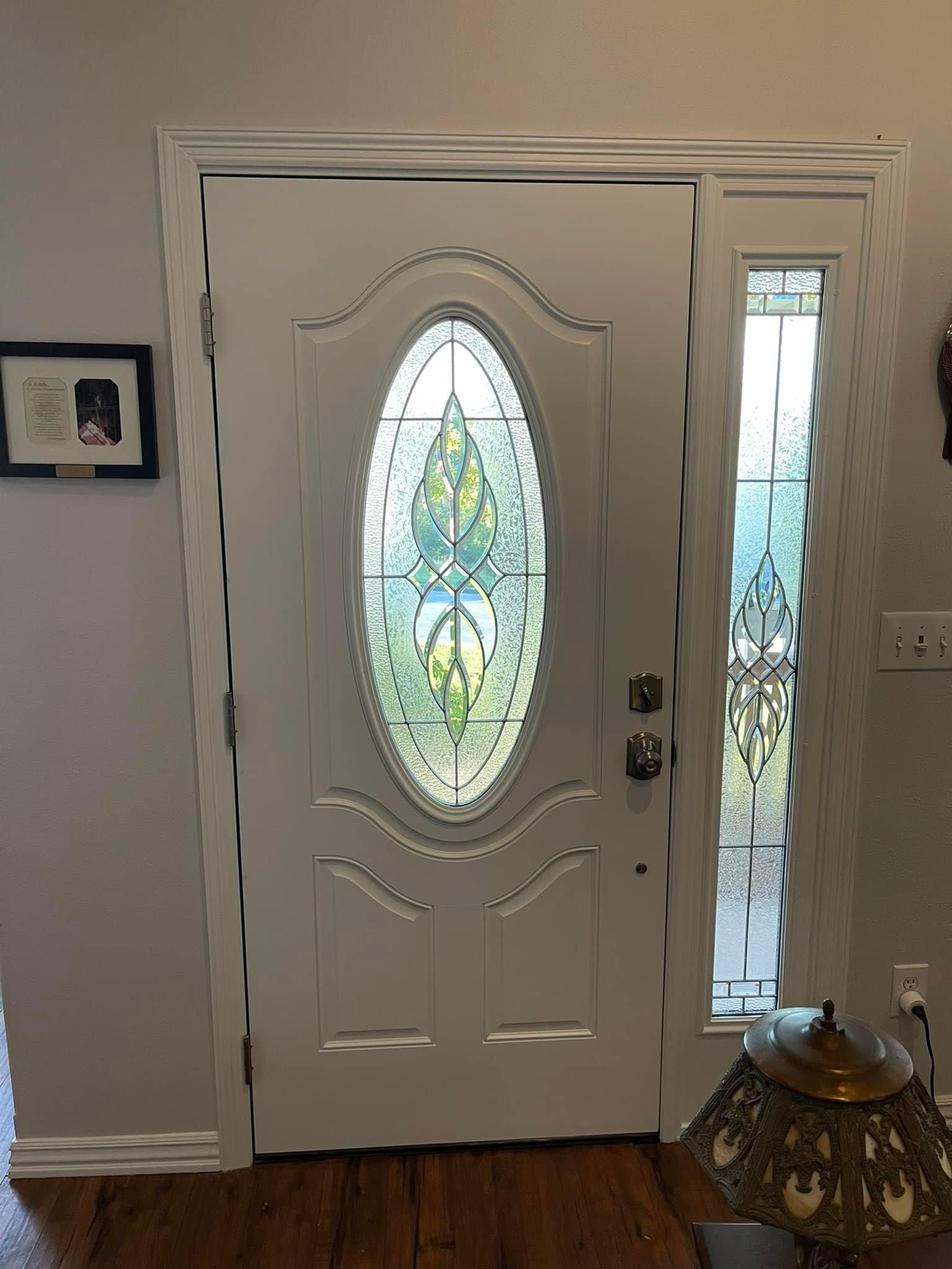 A white door with a stained glass window in a living room.