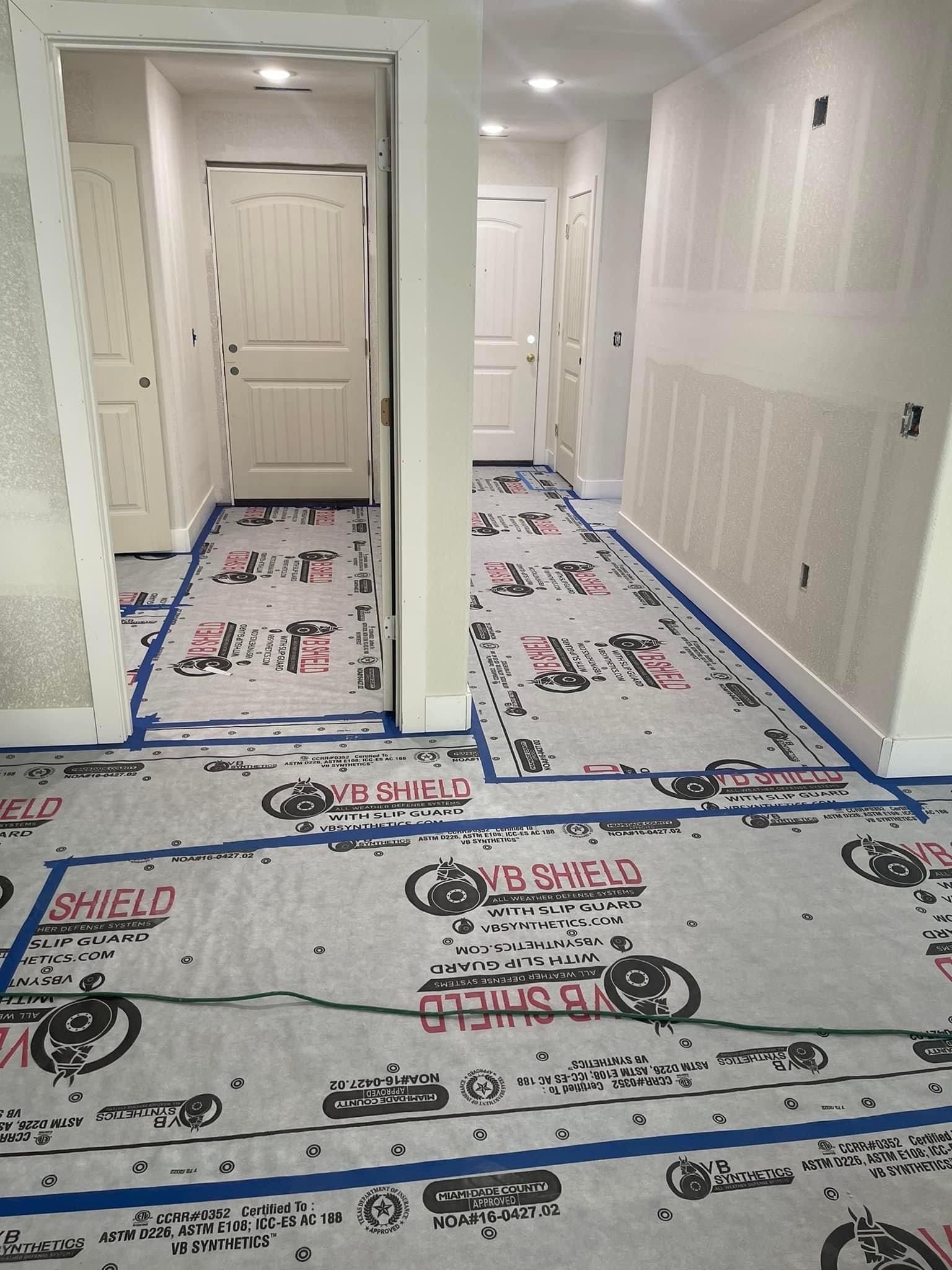 A hallway with a lot of blue tape on the floor.