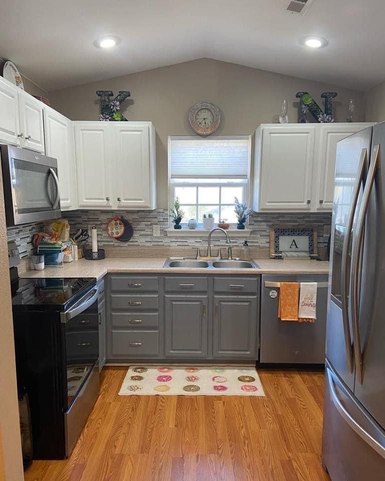 A kitchen with gray cabinets and stainless steel appliances