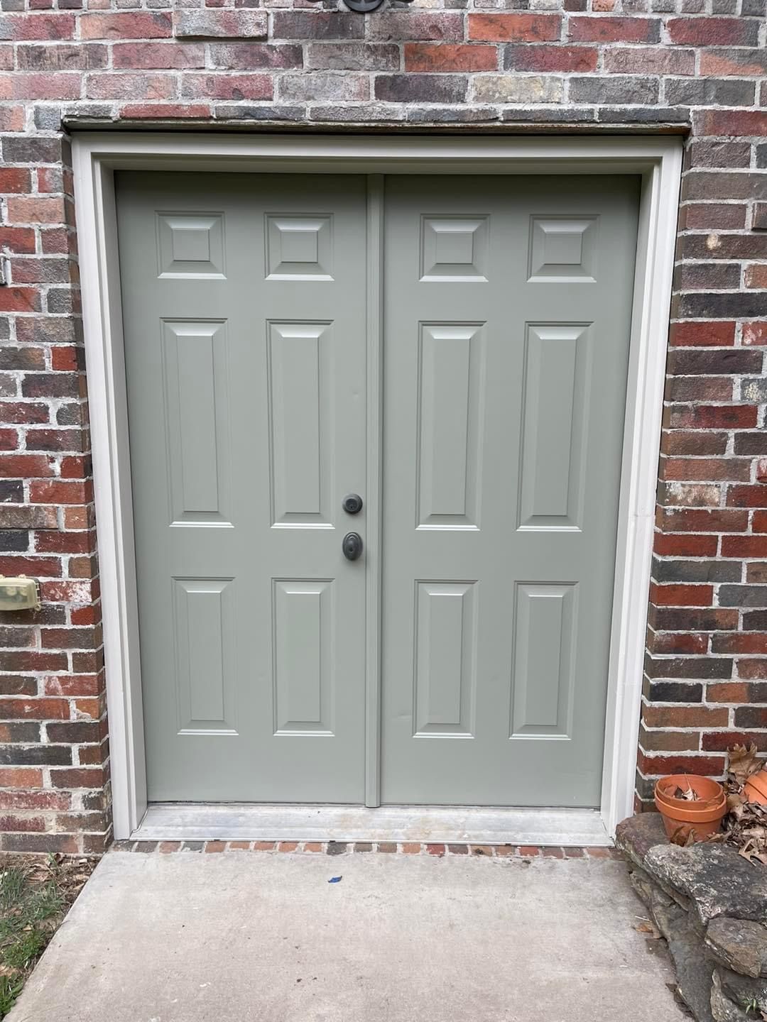 A gray double door on a brick building