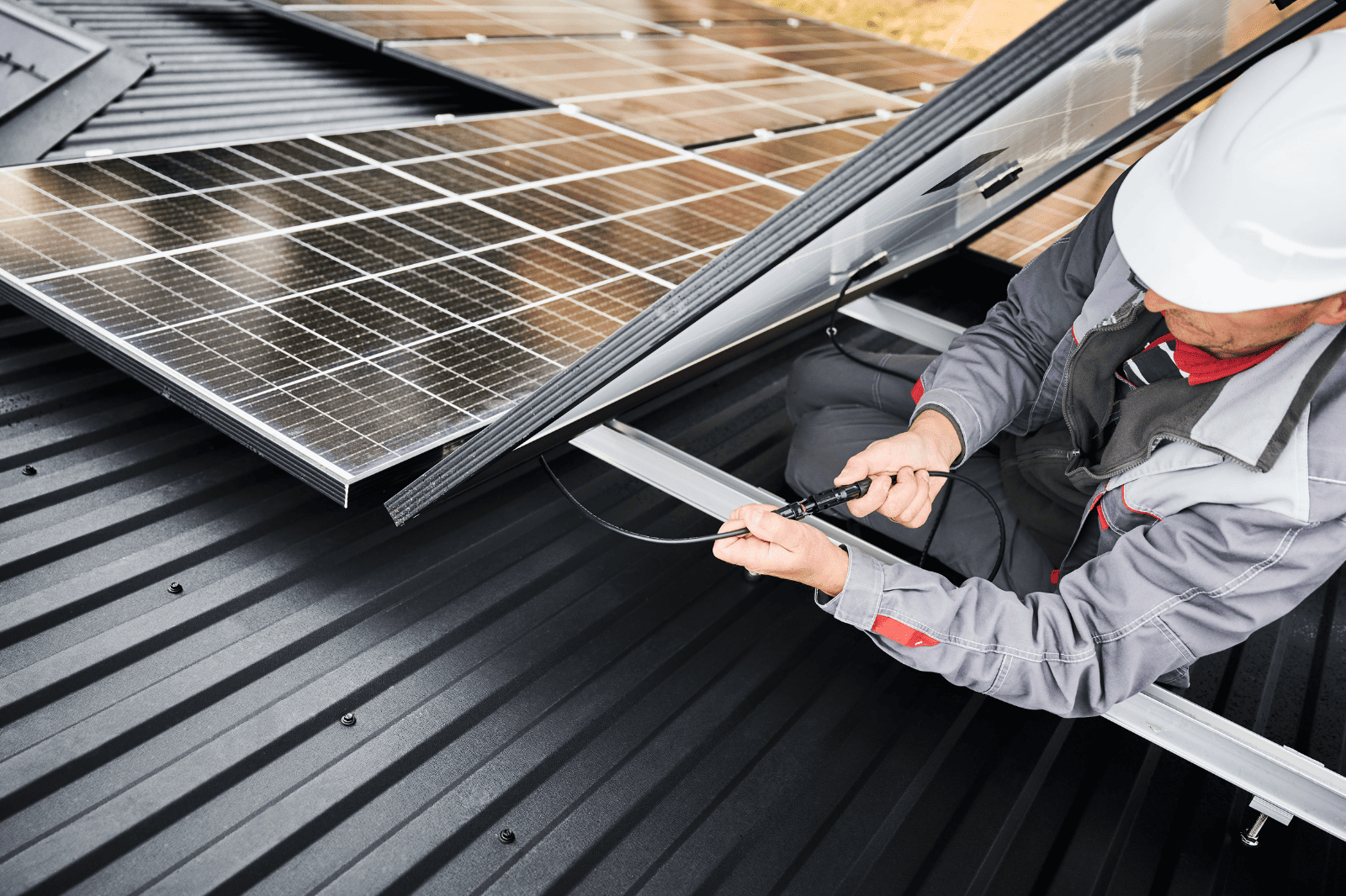Two Men Are Installing Solar Panels on the Roof of a House — B2B Electrical and Solar In Currimundi, QLD Two Men Are Installing Solar Panels on the Roof of a House — B2B Electrical and Solar In Currimundi, QLD