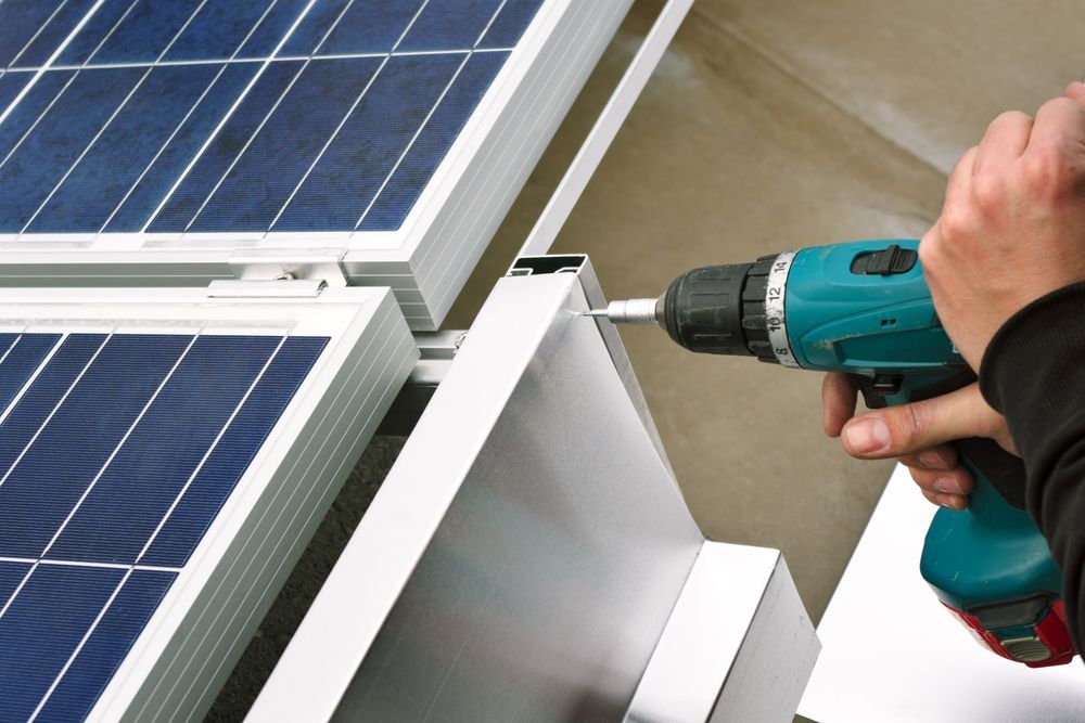 A Person is Working on a Solar Panel With a Drill — B2B Electrical and Solar In Currimundi, QLD