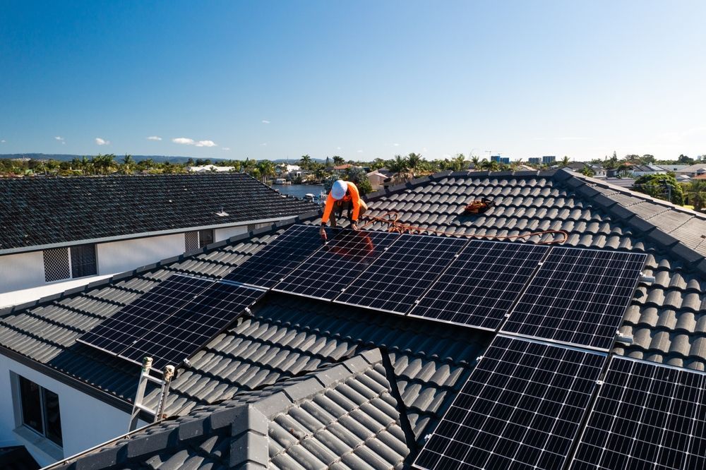 Two Men Are Installing Solar Panels on a Roof — B2B Electrical and Solar In Caloundra, QLD