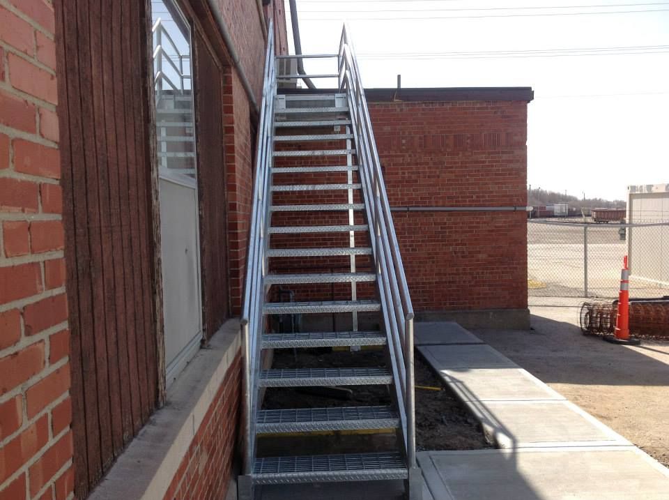 A set of metal stairs leading up to a brick building.