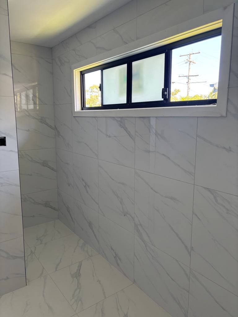 White Marble Tiled Bathroom With Window
